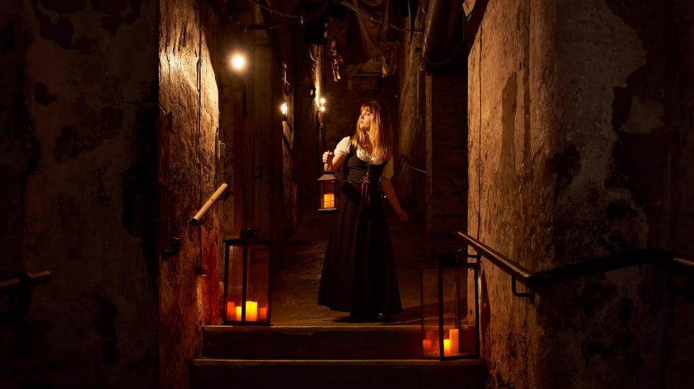 Woman with torch exploring corridors